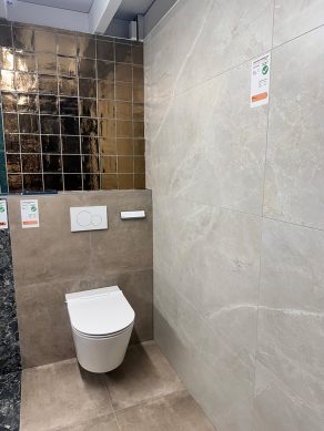 Complete toiletruimte - voorbeeld van onze showroom met; vloertegel betonlook Arca Taupe G42, Vloertegel marmerlook R70, Goude Wandtegels Martini